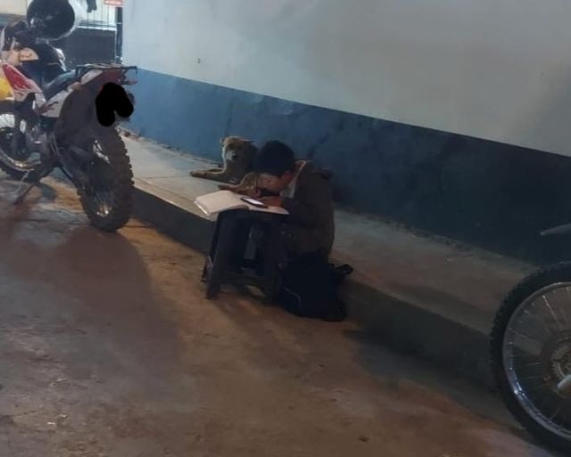Niño realiza su tarea en la calle mientras su madre vende salchipollo en Huamachuco